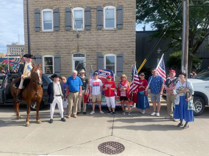 State Rep. Nate Gustafson carries a flag at the City of Appleton's Independence Day celebration.