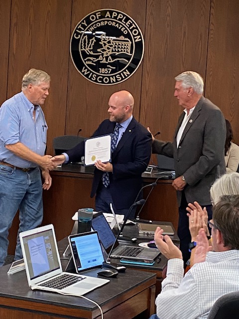 Appleton Mayor Jake Woodford (center) presents an award to Appleton Concerned Taxpayers, represented by Walter Blank (left) and Mike Thomas (right).