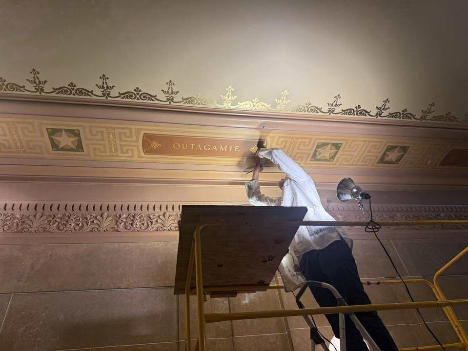 Capitol maintenance restoring the ceiling stenciling for Outagamie and Waupaca counties.